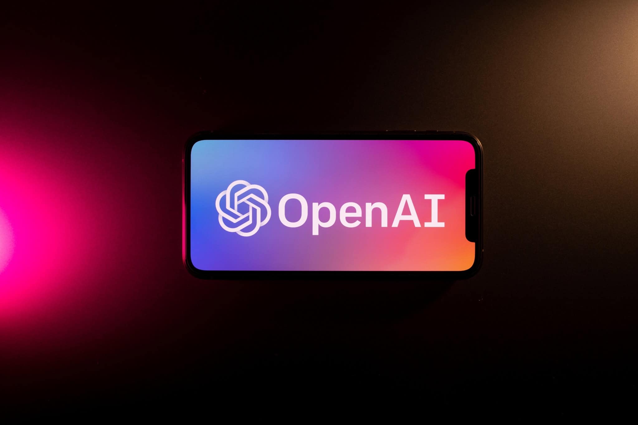 Logo da OpenAI na tela de um smartphone que está na horizontal